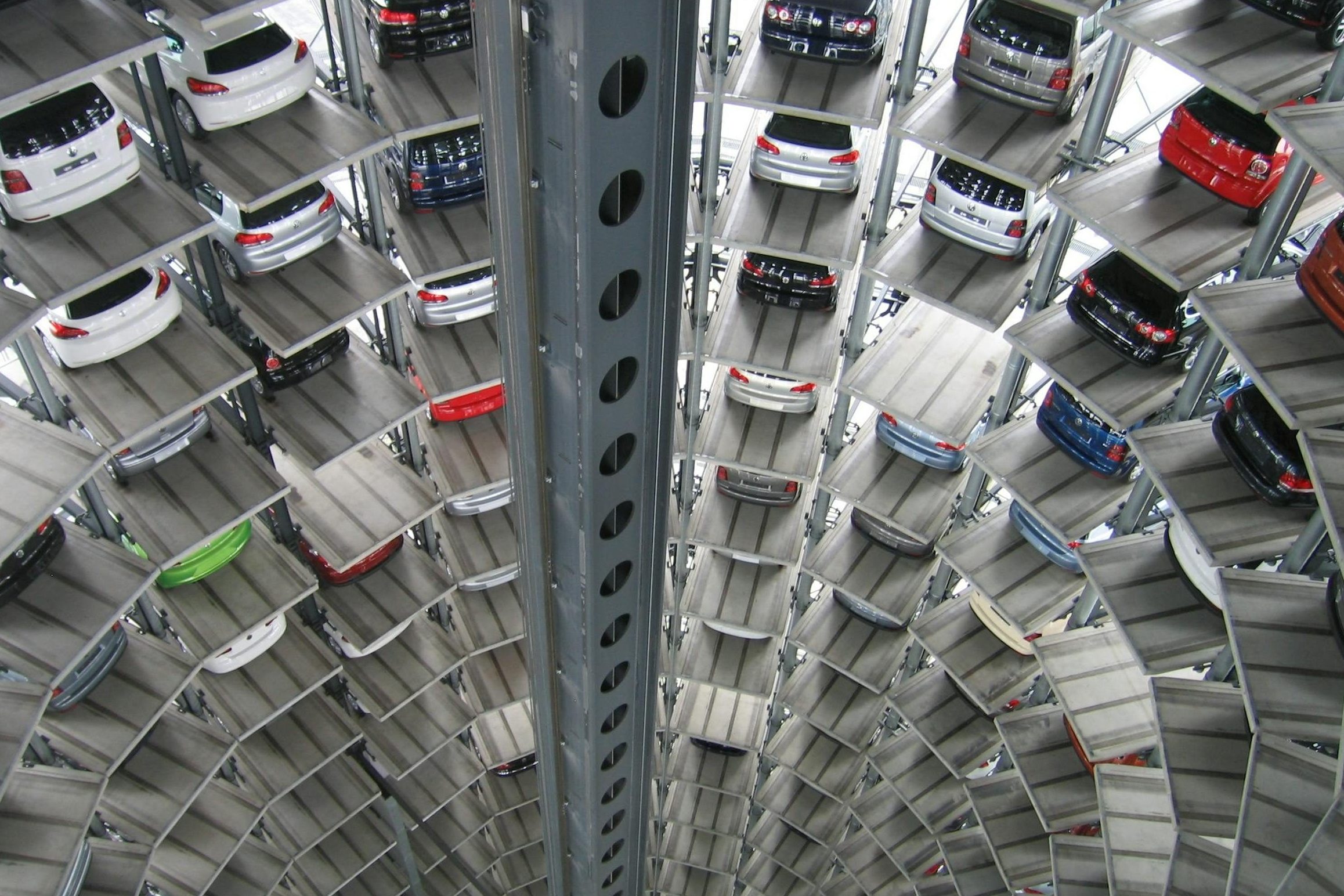 A vertical view of a spiral multi-storey car park filled with vehicles.